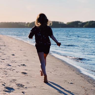 Pige løber på stranden i Middelfart