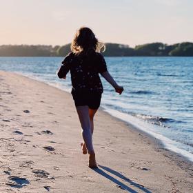 Pige løber på stranden i Middelfart
